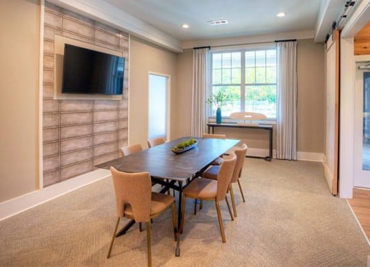a dining room with a table and chairs and a television  at Lullwater at Big Ridge, Hixson, Tennessee