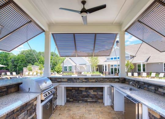 a outdoor kitchen with a grill and a patio  at Lullwater at Big Ridge, Hixson