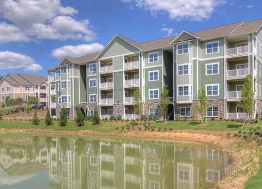 an apartment building with a pond in front of it  at Lullwater at Big Ridge, Hixson