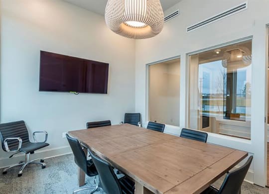 a conference room with a wooden table and black chairs at Livingston Flats Apartments, Chesterfield, VA