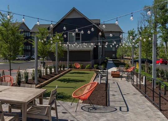 a patio with tables and chairs in front of a building at  Livingston Flats Apartments, Virginia