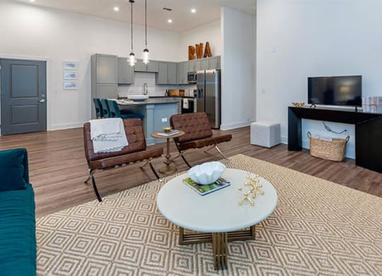 a living room with a table and chairs and a kitchen in the background at Livingston Flats Apartments, Chesterfield, Virginia