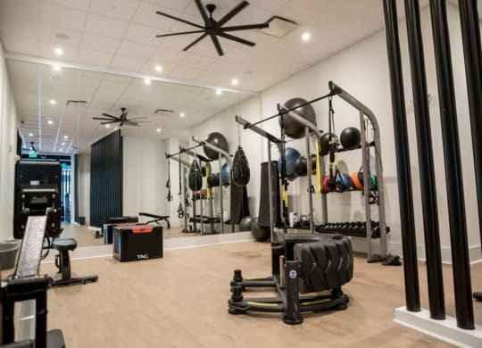 a gym with weights and other exercise equipment at Flats at West Broad Village, Virginia