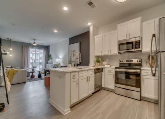 a large kitchen with white cabinets and stainless steel appliances at Flats at West Broad Village, Virginia, 23060