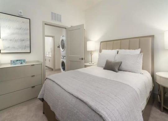 a bedroom with a bed and a washer and dryer at Artistry at Winterfield Apartments, Midlothian, VA, 23112