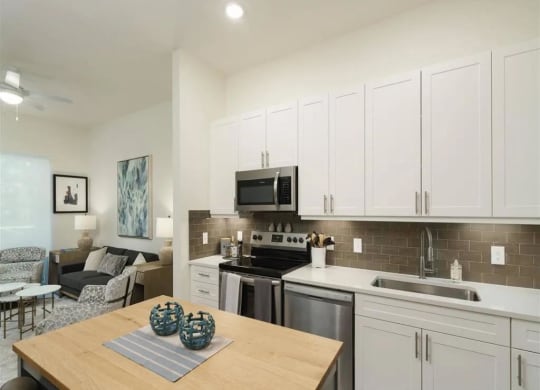 a kitchen with a wooden table and a stove top oven at Artistry at Winterfield Apartments, Midlothian, Virginia