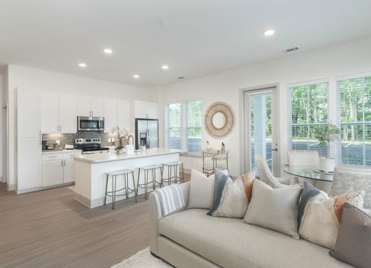 a living room with a couch and a kitchen in the background at Artistry at Winterfield Apartments, Virginia,23112