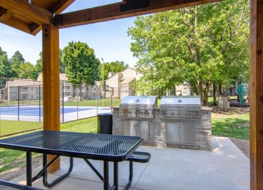 a patio with two grills and a table at Hunters Chase Apartments, Midlothian