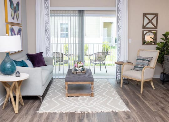 a living room filled with furniture and a large window  at Sapphire at Centerpointe, Midlothian, VA