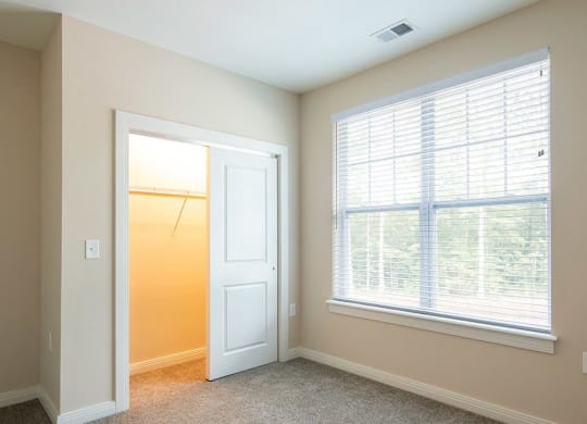 a bedroom with a large window and a closet  at Sapphire at Centerpointe, Midlothian, VA