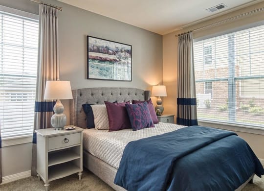 a bedroom with a bed and two windows  at Sapphire at Centerpointe, Midlothian