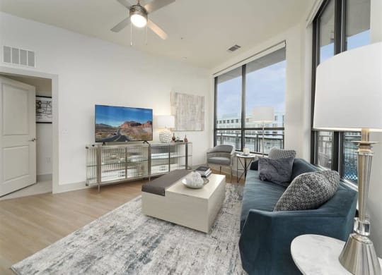 a living room with a large window and a ceiling fan at Tapestry West, VA 23230