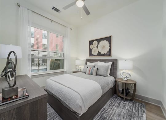 a bedroom with a large window and a ceiling fan at Tapestry West, VA 23230