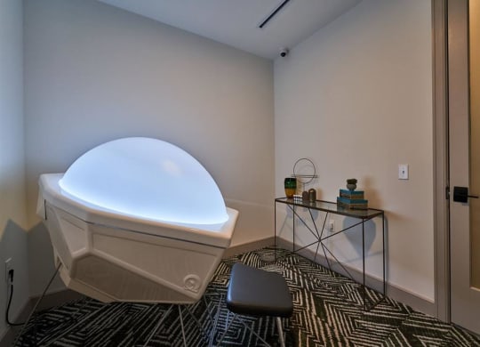 a room with a hot tub and a table with a plant on it