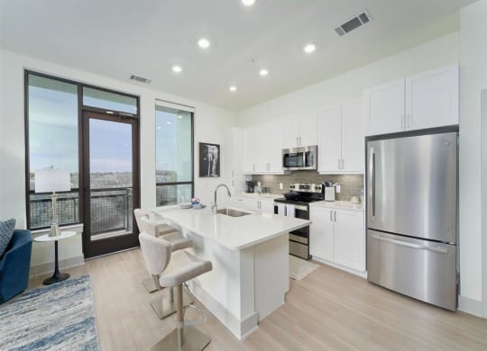 a white kitchen with a large island and stainless steel appliances at Tapestry West, Richmond, 23230