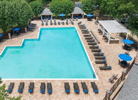 an aerial view of a swimming pool with lounge chairs and umbrellas at Trails at Short Pump Apartments, Richmond ,23233