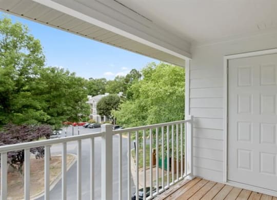 a white door opens to a balcony with a street in the background at Trails at Short Pump Apartments, Richmond
