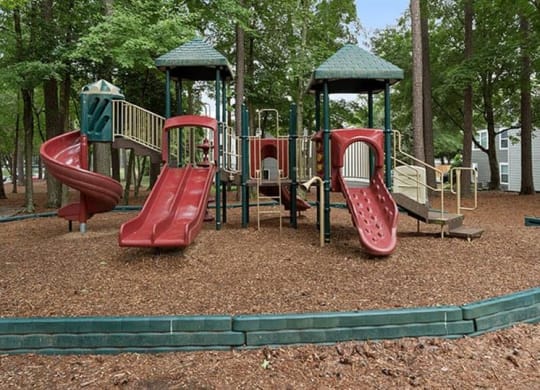 a playground with two slides and two swings at Trails at Short Pump Apartments, Richmond