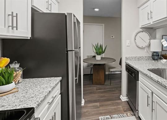 a kitchen with white cabinets and a black refrigerator at Trails at Short Pump Apartments, Virginia,23233