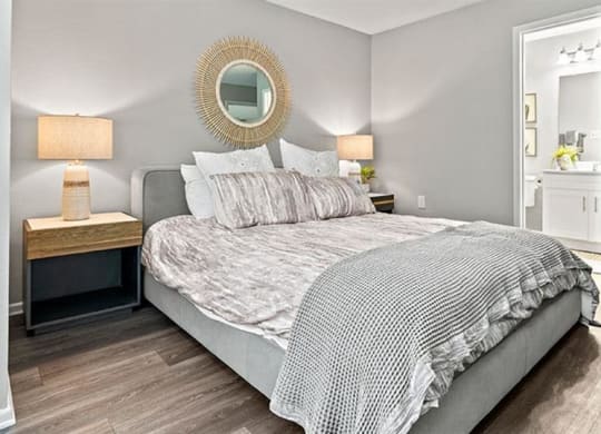 a bedroom with a bed and a mirror at Trails at Short Pump Apartments, Richmond