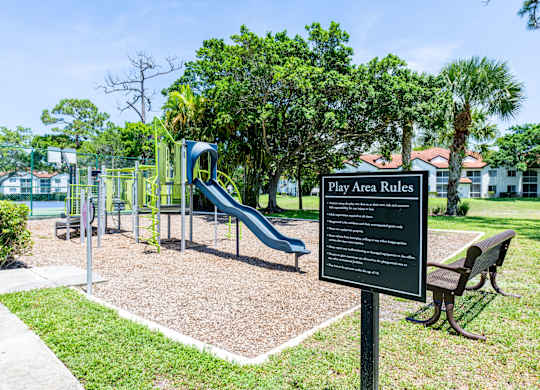 A playground with a sign that reads "Play Area Rules".