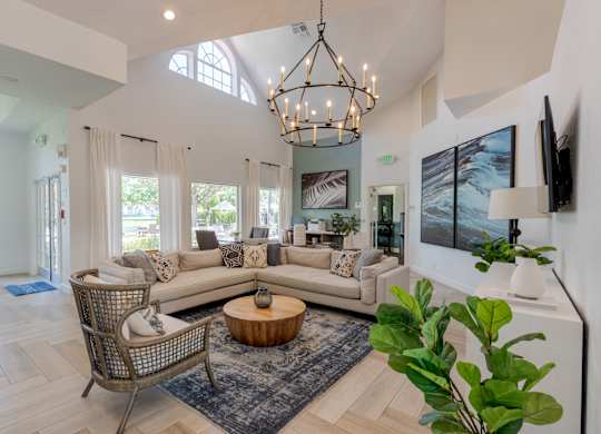 A living room with a large sectional sofa, a coffee table, and a chandelier.