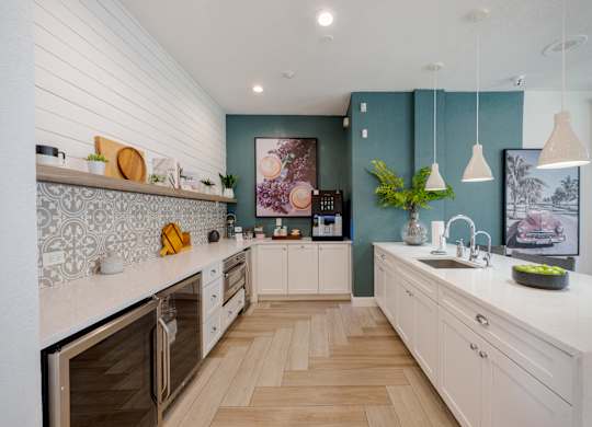 A modern kitchen with wooden floors and white cabinets.