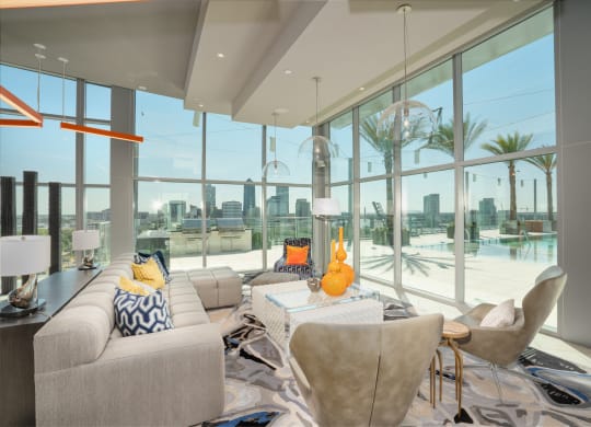 a living room with a view of the water and a couch and chairs at Vista Brooklynn Apartments, Jacksonville