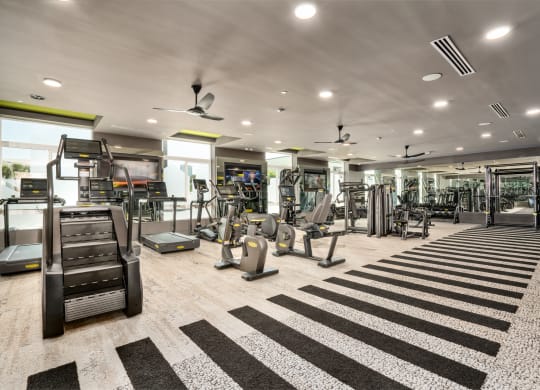 a gym with treadmills and other exercise equipment in a building with white ceilings at Vista Brooklynn Apartments, Jacksonville, Florida