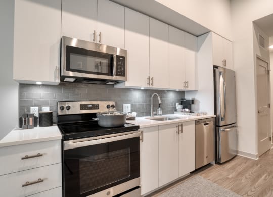 a kitchen with stainless steel appliances and white cabinets at Vista Brooklynn Apartments, Jacksonville, FL, 32202