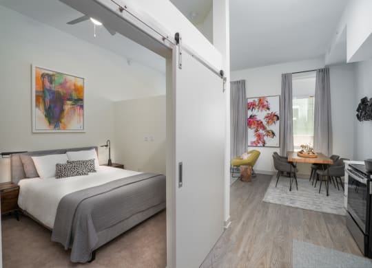 a bedroom with a bed and a living room with a dining room at Vista Brooklynn Apartments, Jacksonville, Florida