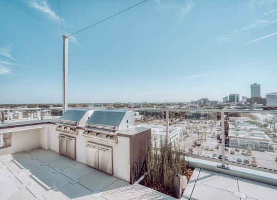 an outdoor terrace with a barbecue grill and a view of the city at Vista Brooklynn Apartments, Jacksonville, Florida