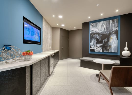 a lobby with a blue wall and a table with chairs at Vista Brooklynn Apartments, Florida