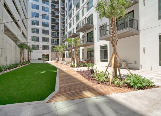 a courtyard with trees and grass in front of an apartment building at Vista Brooklynn Apartments, Jacksonville