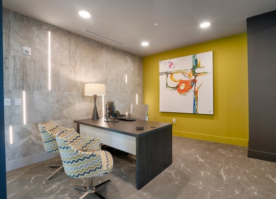 a desk and chairs in a room with a painting at Vista Brooklynn Apartments, Florida