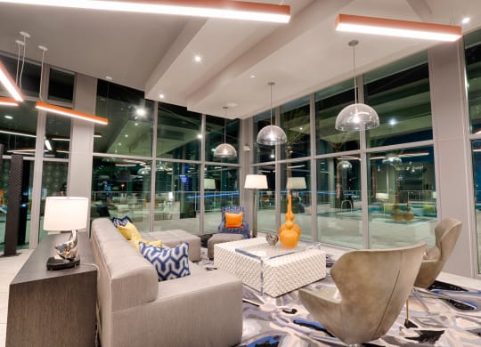 a living room with couches and chairs and large glass windows at Vista Brooklynn Apartments, Jacksonville, 32202