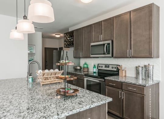 a kitchen with granite counter tops and wooden cabinets at Village at Westland Cove Apartments, Tennessee, 37922