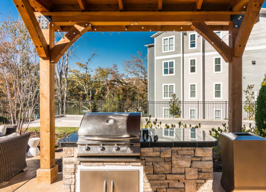 an outdoor kitchen with a grill and a wooden structure at Village at Westland Cove Apartments, Knoxville, TN, 37922