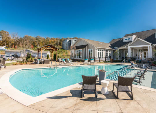 a large swimming pool with chairs and a house in the background at Village at Westland Cove Apartments, Knoxville, 37922