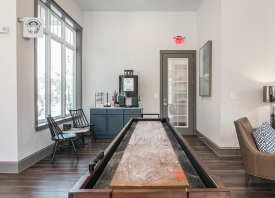 the living room has a shuffleboard table in the middle of it at Village at Westland Cove Apartments, Knoxville, TN, 37922