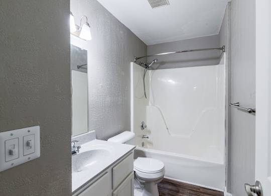 A white bathroom with a toilet, sink, and bathtub.