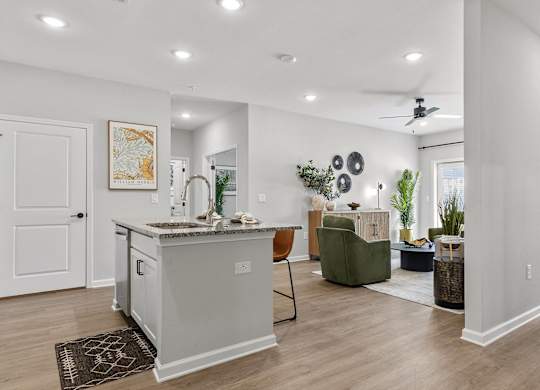 A kitchen with a white counter and a green chair.