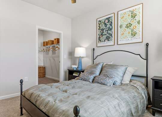A bedroom with a bed, nightstand, and lamp.