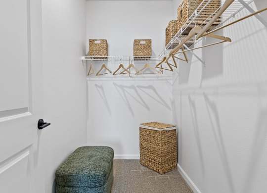 A white hallway with a bench and a basket on the floor.