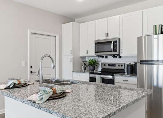 A kitchen with granite countertops and stainless steel appliances.
