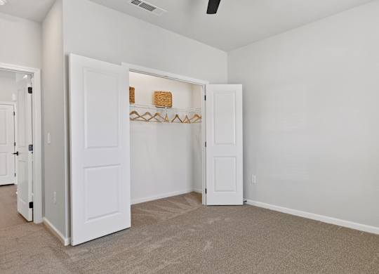 A room with a white door and a shelf with a few items on it.