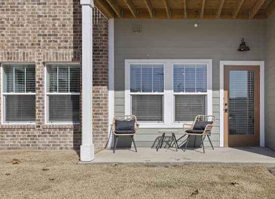 A house with a brown brick wall and a white door.