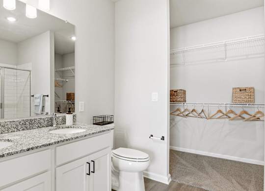 A white bathroom with a toilet, sink, and mirror.