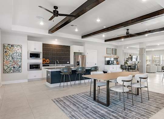A modern open-plan living and dining area with a kitchen in the background.