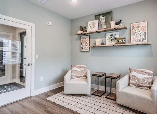 A living room with two chairs and a table.